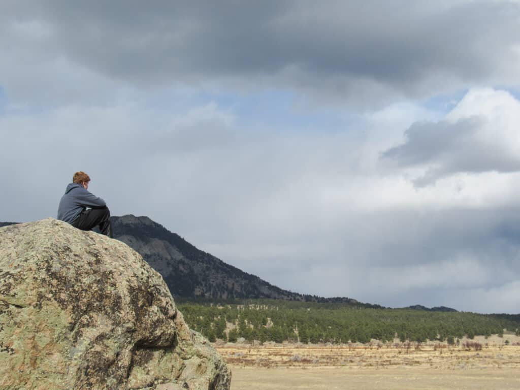 Teenage Boy looks out over Moraine Valley in Rocky Mountain National Park
