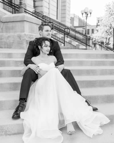 lovely wedding couple sits on the courthouse stairs on their wedding day
