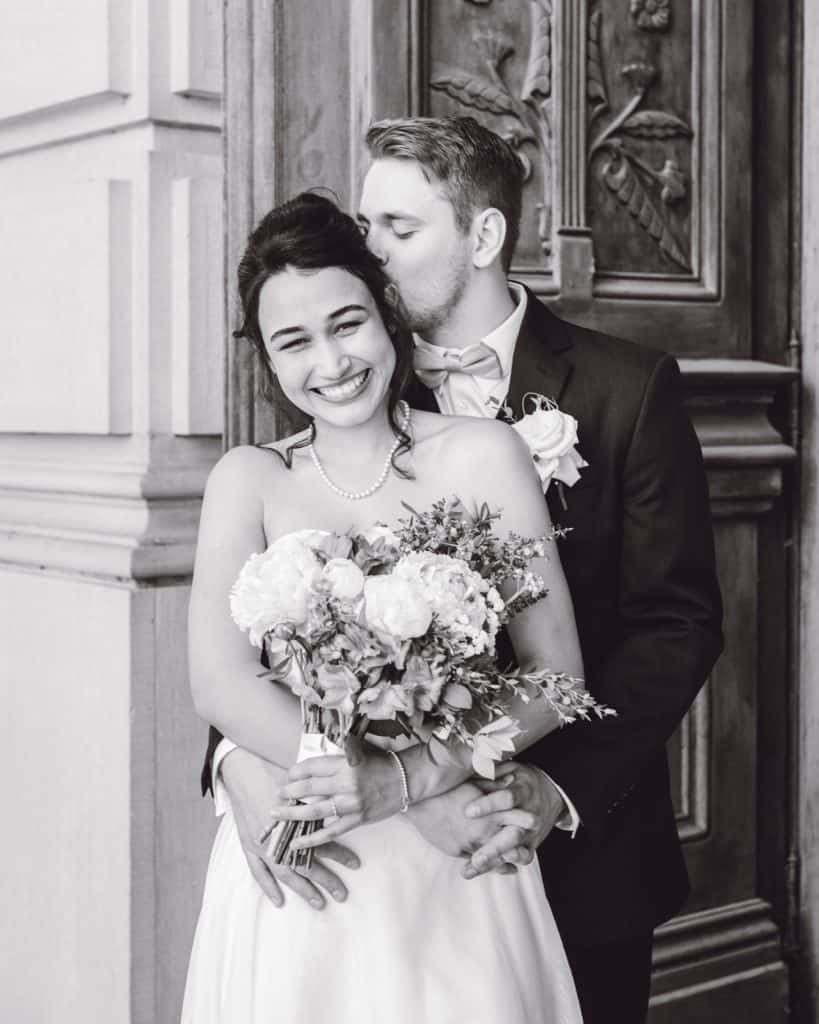 lovely wedding couple poses in front of the courthouse doors on their wedding day