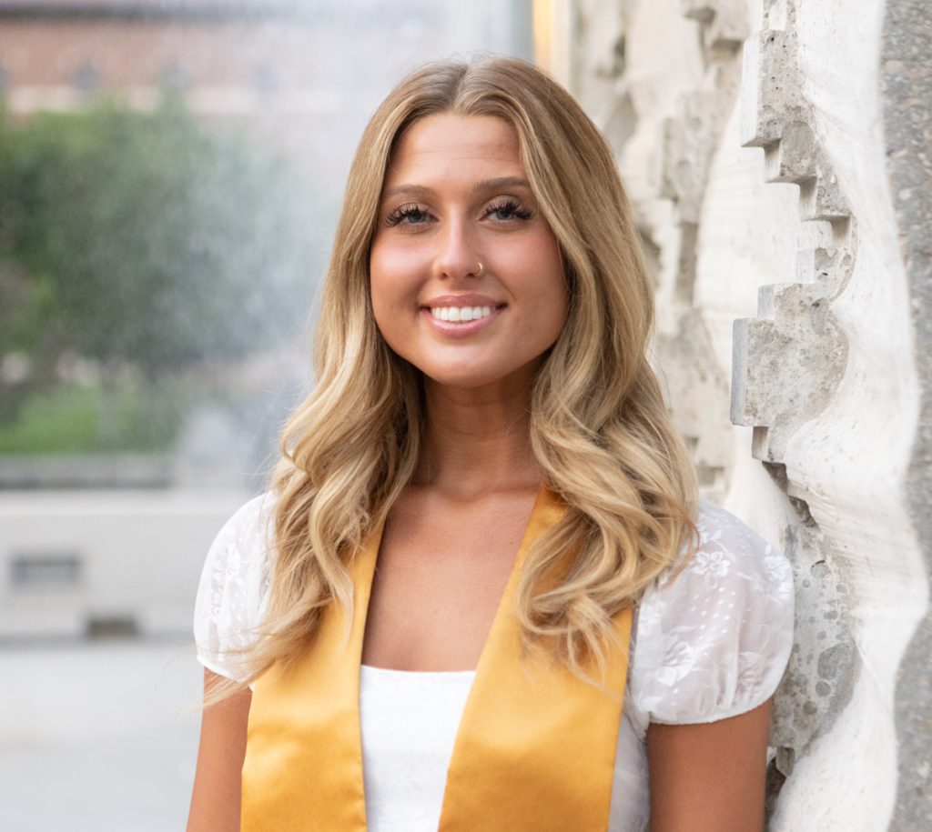 Purdue graduate smiles at the Purdue engineering fountain for her grad photo session