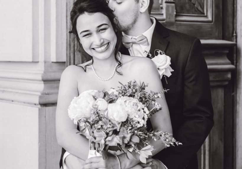 lovely wedding couple poses in front of the courthouse doors on their wedding day